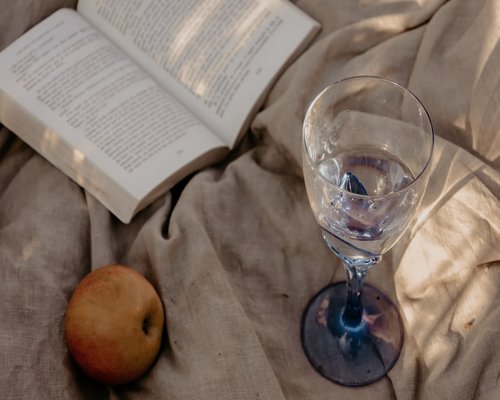 A glass of water next to an open book